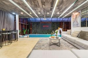 a living room with a couch and a table at Ultimate 9BR Lleras Villa W Heated Pool in Medellín