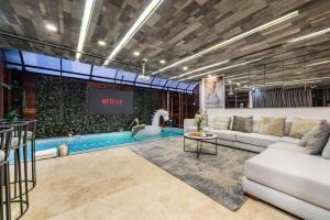 a living room with a couch and a swimming pool at Ultimate 9BR Lleras Villa W Heated Pool in Medellín