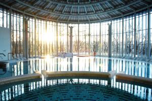 a large pool in a building with a large window at Table Rase chambres d'hôtes, restaurant et weekend aux Thermes de Spa in Theux