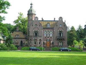 a large house with two cars parked in front of it at Carpe Diem in Ommen