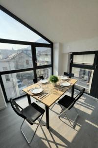 a dining table and chairs in a room with large windows at Tibetan BB in Bellinzona