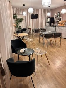 a group of tables and chairs in a room at Le Lion dOr Hôtel de Charme et centre ville de Bernay in Bernay