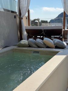 a pool of water with cushions on a patio at Tango Studios in Paleokastritsa