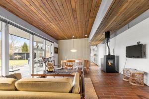 a living room with a couch and a table at 84307-8400-Skovduevej-4 in Fuglslev