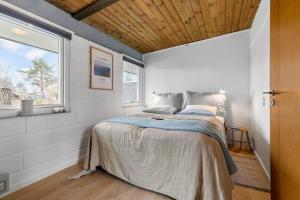 a bedroom with a bed in a room with a window at 84307-8400-Skovduevej-4 in Fuglslev