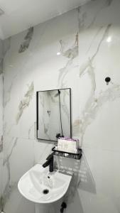 a white bathroom with a sink and a mirror at نسمة الخبر كورنيش اقامة رائعة وهادئة in Dammam +38 photos