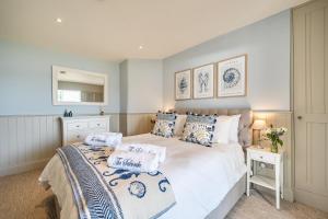 a bedroom with a white bed with blue and white pillows at No 5 The Salcombe in Salcombe