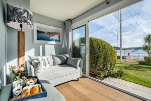 a living room with a couch and a large window at No 5 The Salcombe in Salcombe