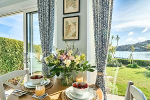 a dining room table with a vase of flowers on it at No 5 The Salcombe in Salcombe
