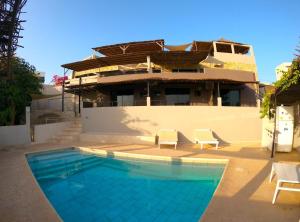a house with a swimming pool in front of a building at Villa Koté Océan in Toubab Dialaw