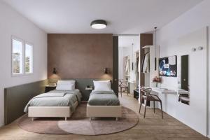 a bedroom with two beds and a desk at Hotel Sayonara in Milano Marittima