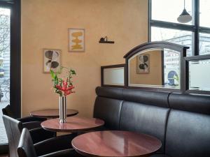 a waiting room with two tables and a bench at Flemings Hotel Bremen-Hauptbahnhof in Bremen