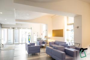 a living room with blue chairs and a couch at Hotiday Brindisi Vittoria in Brindisi