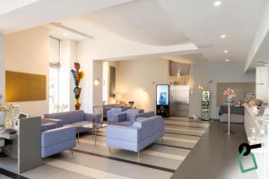 a living room with blue couches and a room with at Hotiday Brindisi Vittoria in Brindisi