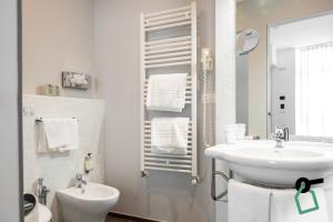 a white bathroom with a sink and a toilet at Hotiday Brindisi Vittoria in Brindisi +26 photos