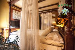 a bedroom with a bed with a bed frame and a lamp at Hotel Ruralis Peña Del Alba in Arroyomolinos de la Vera