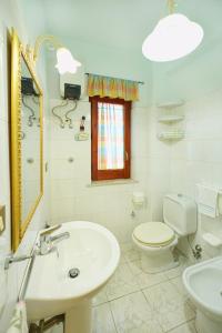 a white bathroom with a sink and a toilet at Armonia del Mare in Mascali