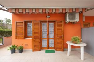 a house with wooden doors and a table in front of it at Armonia del Mare in Mascali