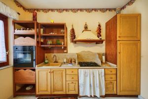 a kitchen with wooden cabinets and a sink at Armonia del Mare in Mascali