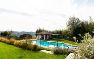 a swimming pool in a garden with a gazebo at Relais dei Poderi Einaudi in Dogliani