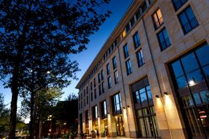a large building with a tree in front of it at Flemings Hotel Bremen-Hauptbahnhof in Bremen