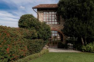 a brick house with a window and a chair in the yard at Relais dei Poderi Einaudi in Dogliani +59 photos
