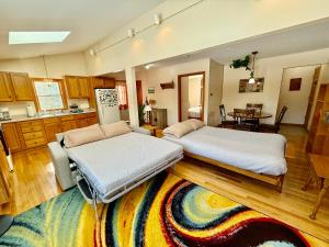 two beds in a room with a kitchen at The Suite at Liberty Woods in Belchertown