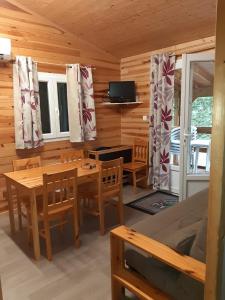 a dining room with a table and chairs in a cabin at Chalet in Marcilly-sur-Eure