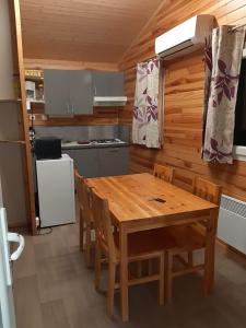 a kitchen with a wooden table and chairs at Chalet in Marcilly-sur-Eure +1 photo