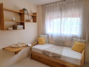 a bed in a room with a window and a table at Sea View Apartman Daimus in Daimuz +14 photos