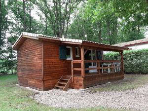 a small wooden cabin with a porch and a ladder at Chalet in Marcilly-sur-Eure