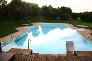 a large swimming pool in the middle of a yard at Hotel Ruralis Peña Del Alba in Arroyomolinos de la Vera