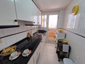 a kitchen with white walls and a black counter top at Sea View Apartman Daimus in Daimuz
