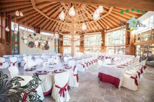 a banquet hall with white tables and red chairs at Hotel Ruralis Peña Del Alba in Arroyomolinos de la Vera