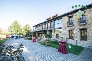 a brick building with purple curtains in front of it at Hotel Ruralis Peña Del Alba in Arroyomolinos de la Vera