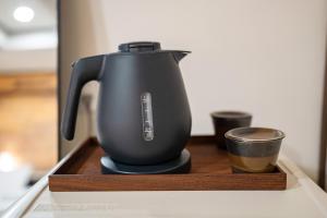 a tea pot sitting on a counter with a cup at oyasumi hotel 道頓堀 Zero-pressure mattress in Osaka