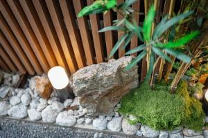 a garden with a rock and a plant and a light at oyasumi hotel 道頓堀 Zero-pressure mattress in Osaka