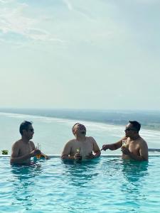 a group of three men sitting in a swimming pool at MeZZO Villa in Ayah