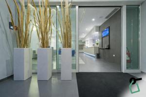 a lobby with two white pillars with plants in them at Hotiday Brindisi Vittoria in Brindisi