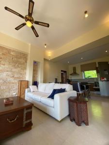 a living room with a white couch and a ceiling fan at Mandharini UNIT 35 in Kilifi