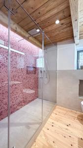 a bathroom with a shower and a red brick wall at Cavigliano Rustico - free parking in Cavigliano +77 photos