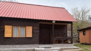 a small wooden cabin with a red roof at Shpija Ujevara e Vogel 2 in Theth +18 photos