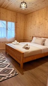 a bedroom with a large bed in a room with wooden walls at Shpija Ujevara e Vogel 2 in Theth