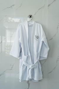 a white robe is hanging on a wall at Mansion Altamirano Hotel in San Antonio
