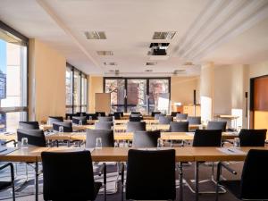 a large room with tables and chairs and windows at Flemings Hotel Bremen-Hauptbahnhof in Bremen +25 photos