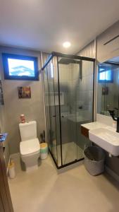 a bathroom with a shower and a toilet and a sink at Pousada Casa Zoe Búzios in Búzios +21 photos