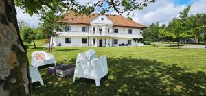 a group of chairs sitting in the grass in front of a house at Gościniec Husarski in Sandomierz