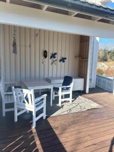 a porch with a table and chairs on a deck at Fjærestua in Hitra