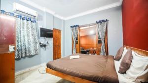 a bedroom with a bed and a tv in a room at Redwing Peaceful Studio in Navi Mumbai