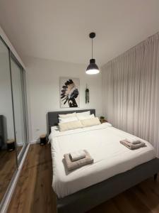 a bedroom with a large white bed with towels on it at Golf Residence Suite & pool in Eilat +31 photos